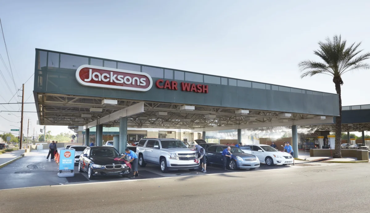 A wide shot of a Jacksons location with a detailing technician working on a vehicle
